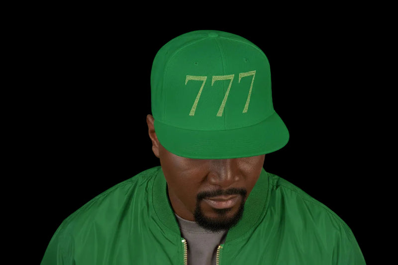 Green cap with embroidered text and logo worn by a person on a white background