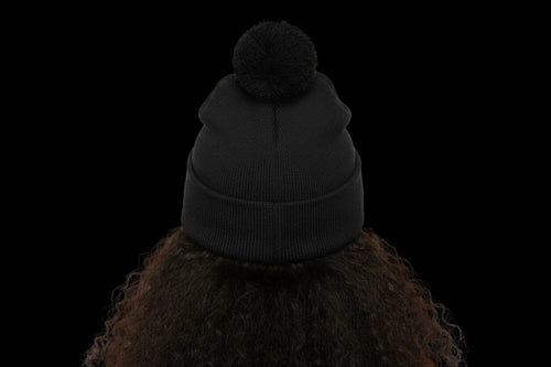 Black beanie with pom-pom on a white background