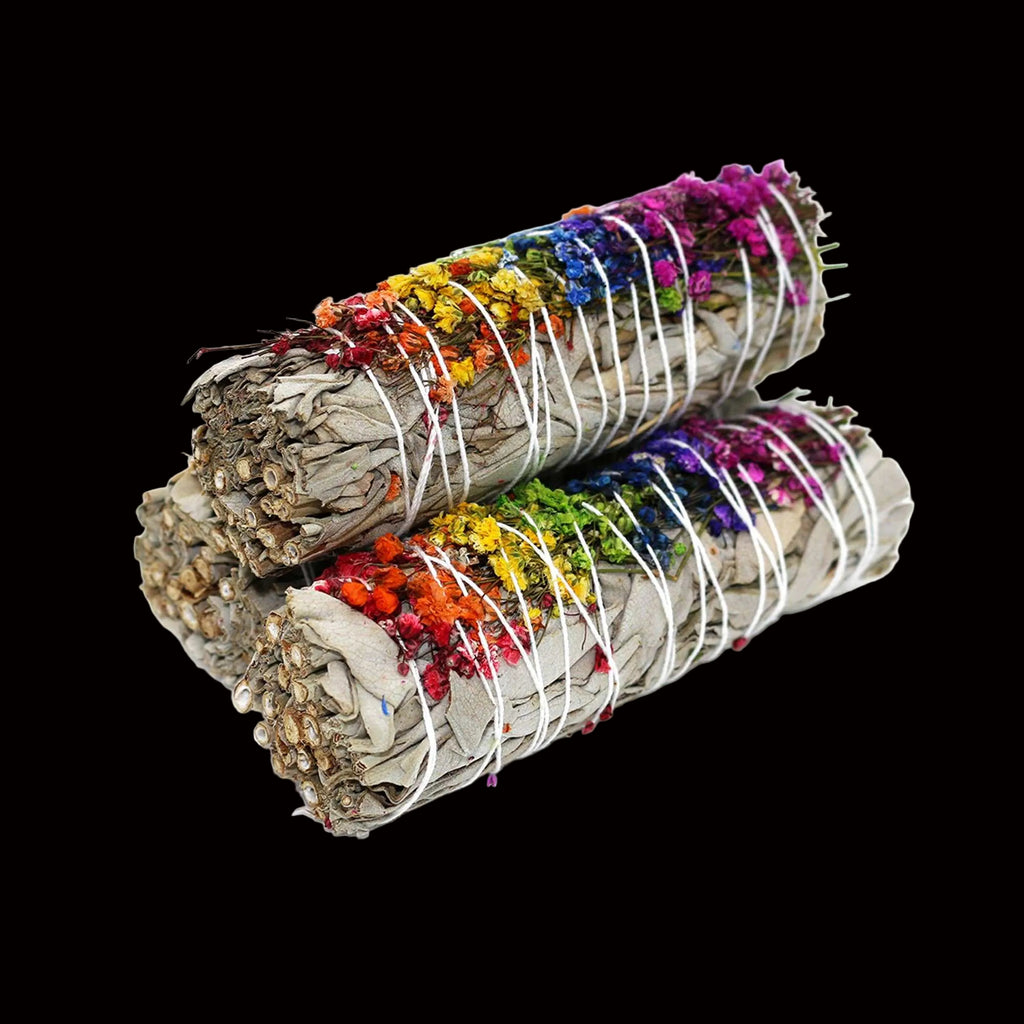 Two bundles of sage with colorful flowers and white ribbons on a white background