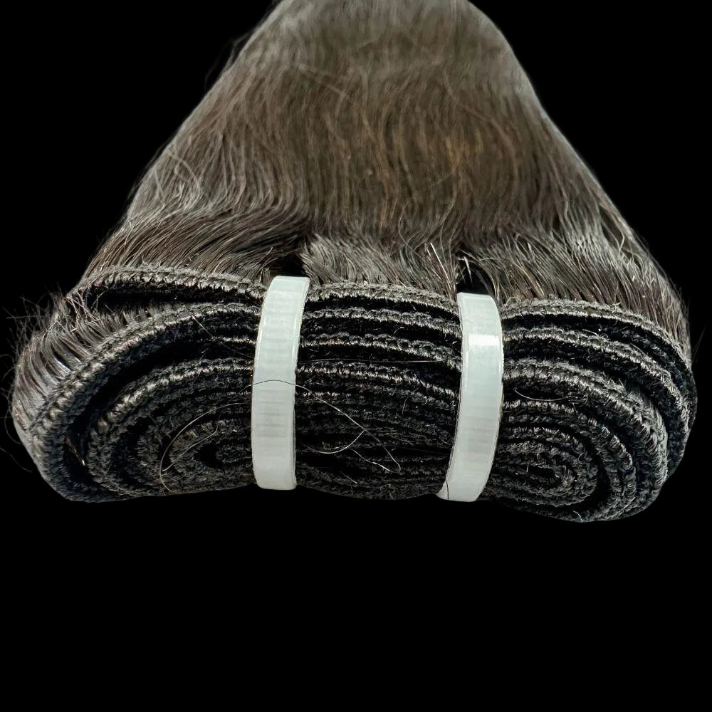 Roll of brown hair extensions with a white band on a white background