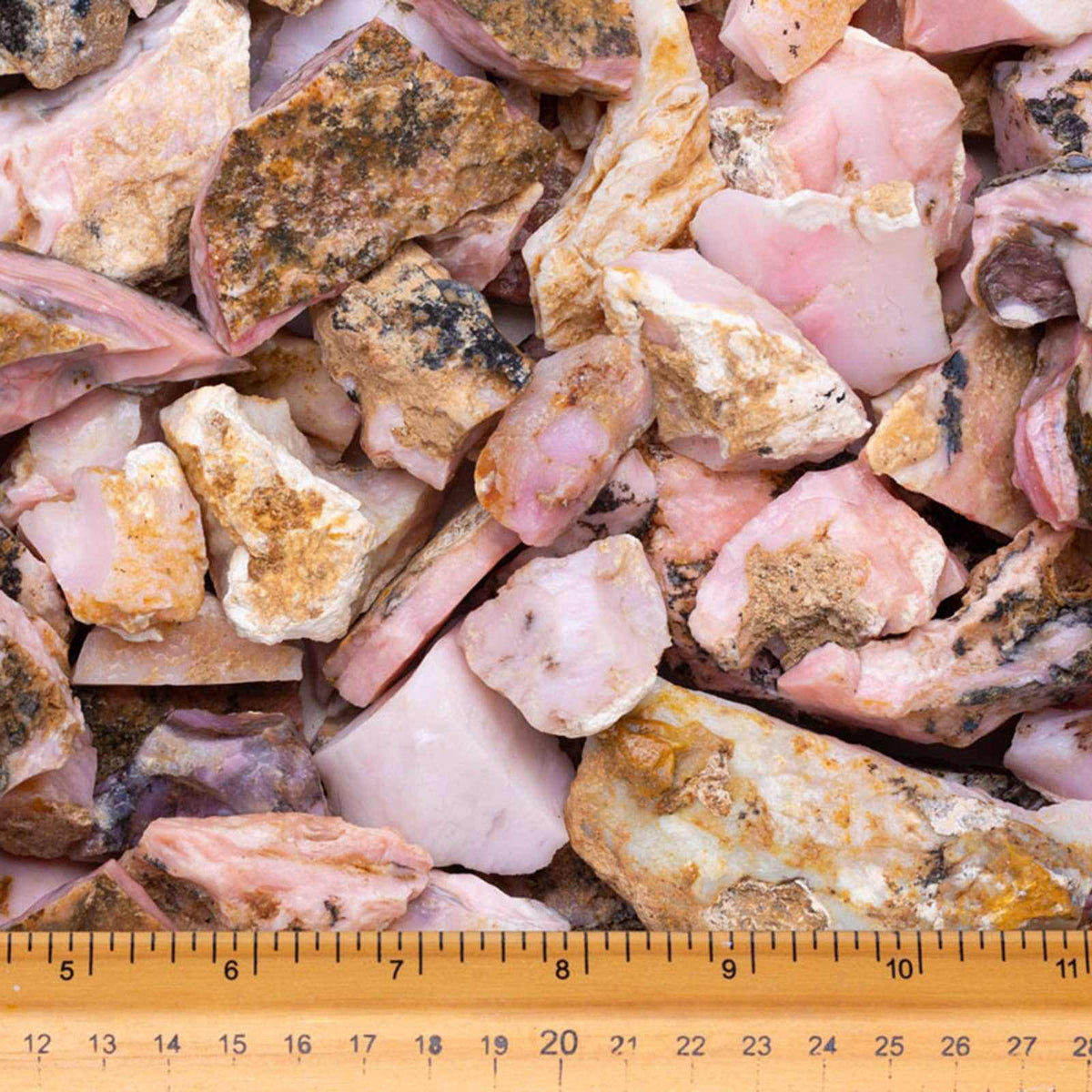 Assorted pink and brown rocks with a ruler at the bottom for scale.