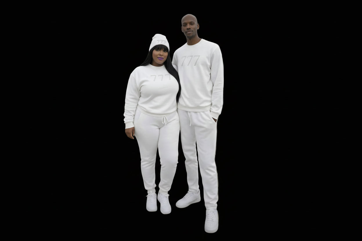 Two people wearing matching white outfits with '777' branding, standing by a waterfront with city skyline in the background.