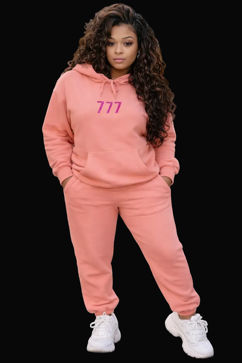 Person wearing a pink tracksuit with '777' on the hoodie, standing on a sidewalk.