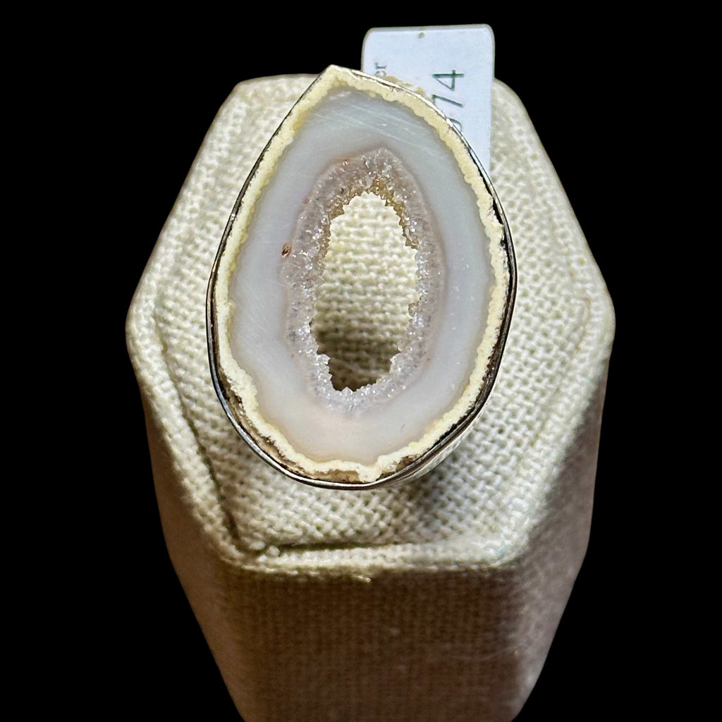 Geode crystal on a white cushion with a black background