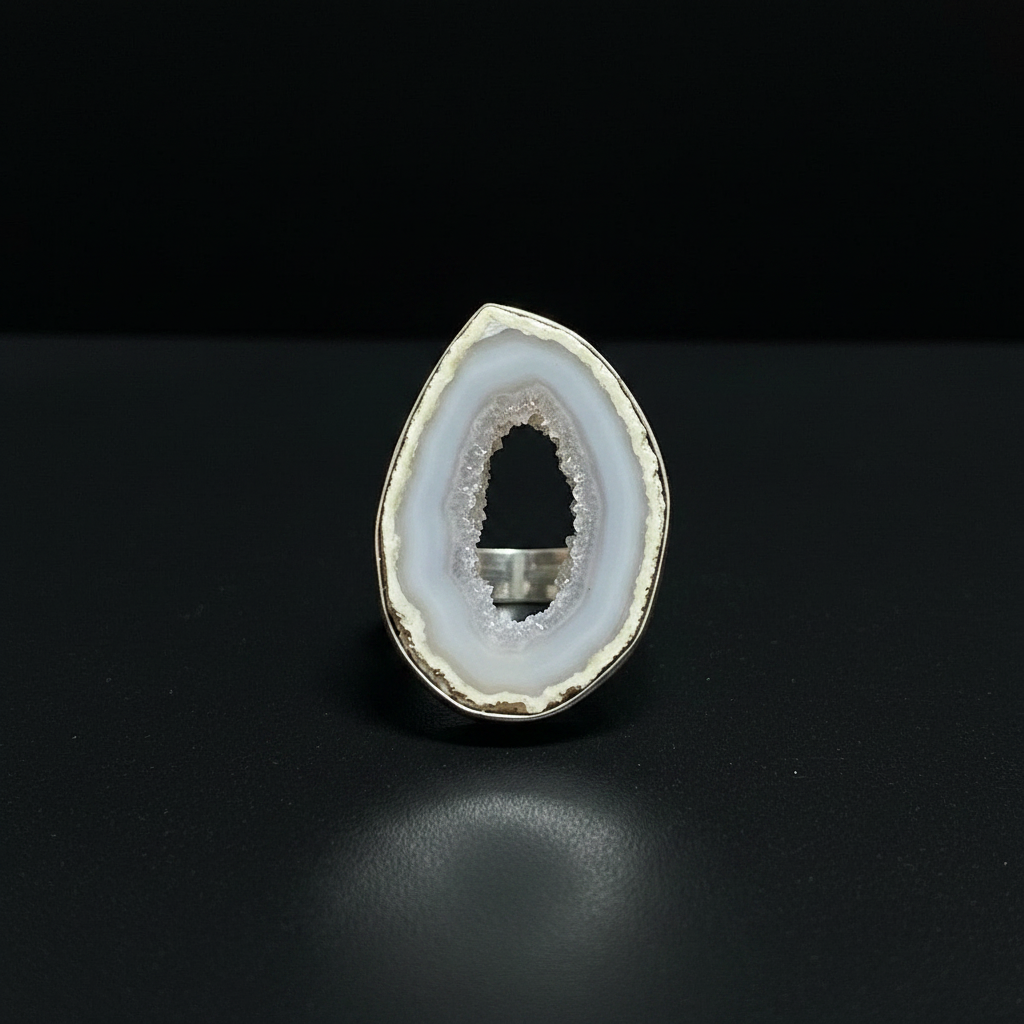 Geode crystal on a white cushion with a black background