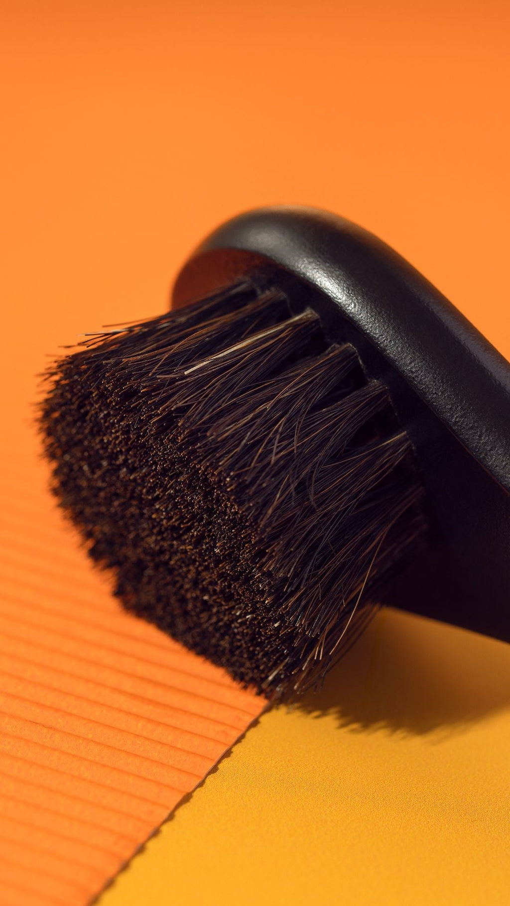Black brush with bristles on an orange background