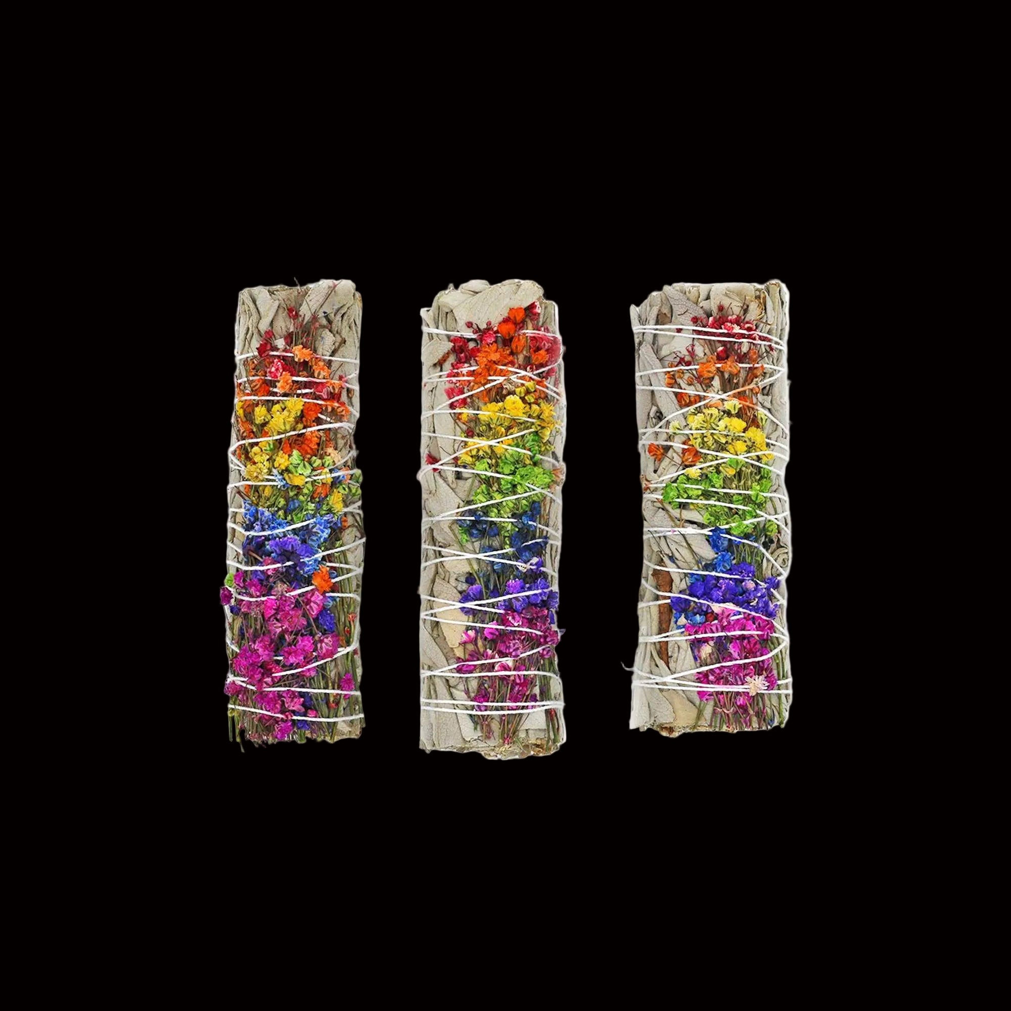 Three colorful smudge sticks with floral elements on a white background