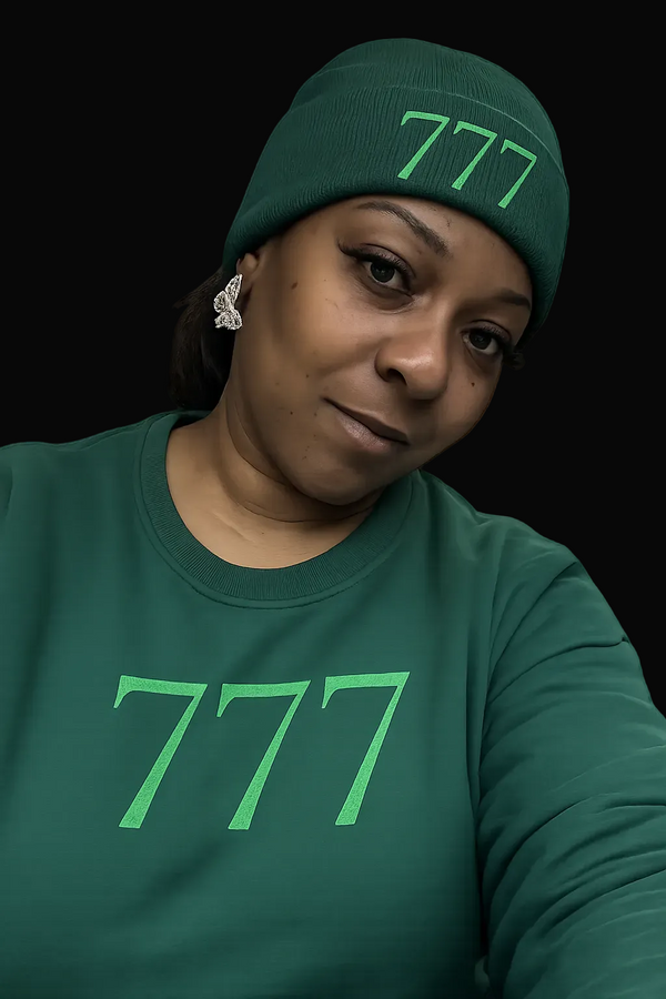 Person wearing a green beanie and shirt with '777' print on a white background