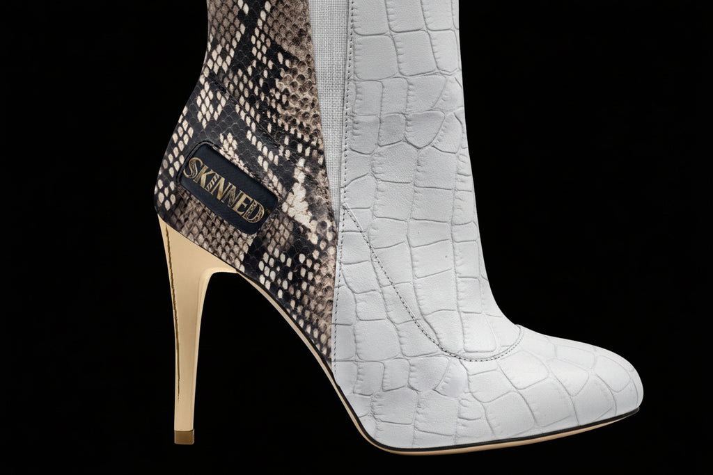 High-heeled shoe with snake print and crocodile texture, featuring the brand 'Skinner'.