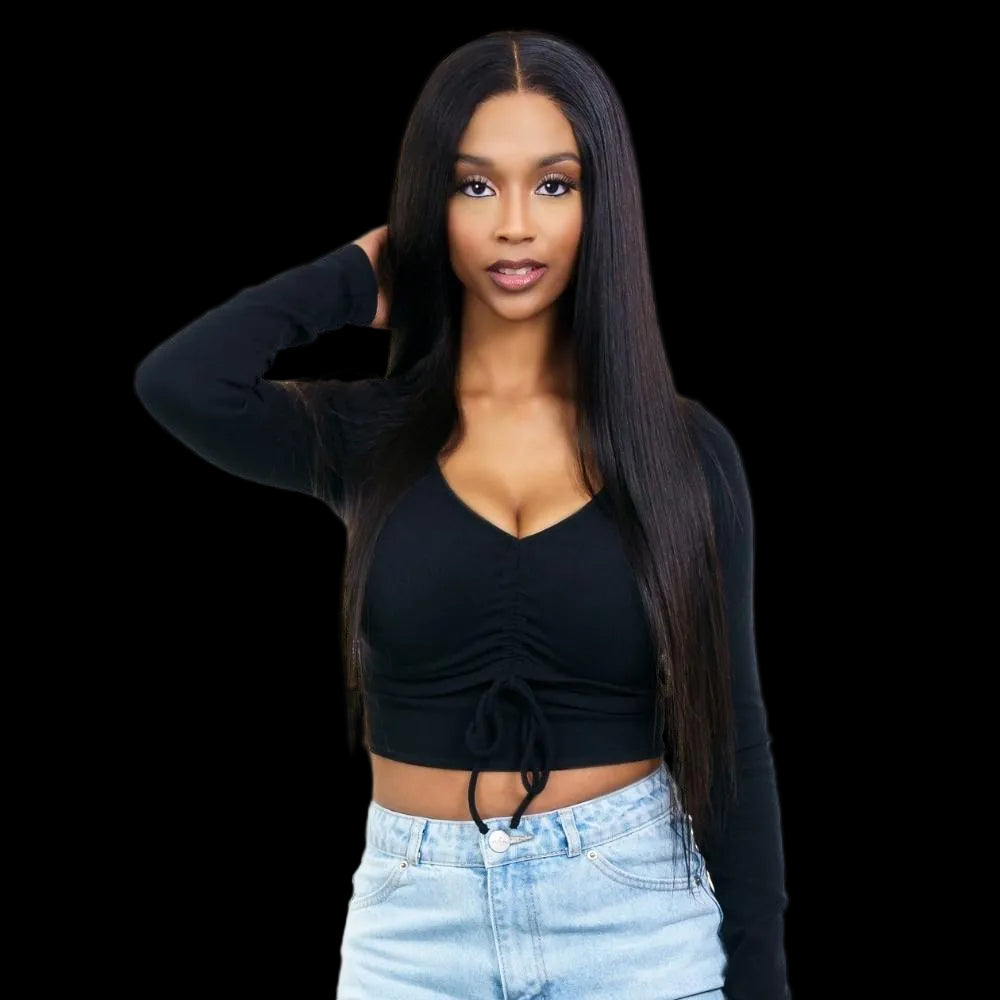 Woman wearing a black long-sleeve top and light blue jeans on a white background